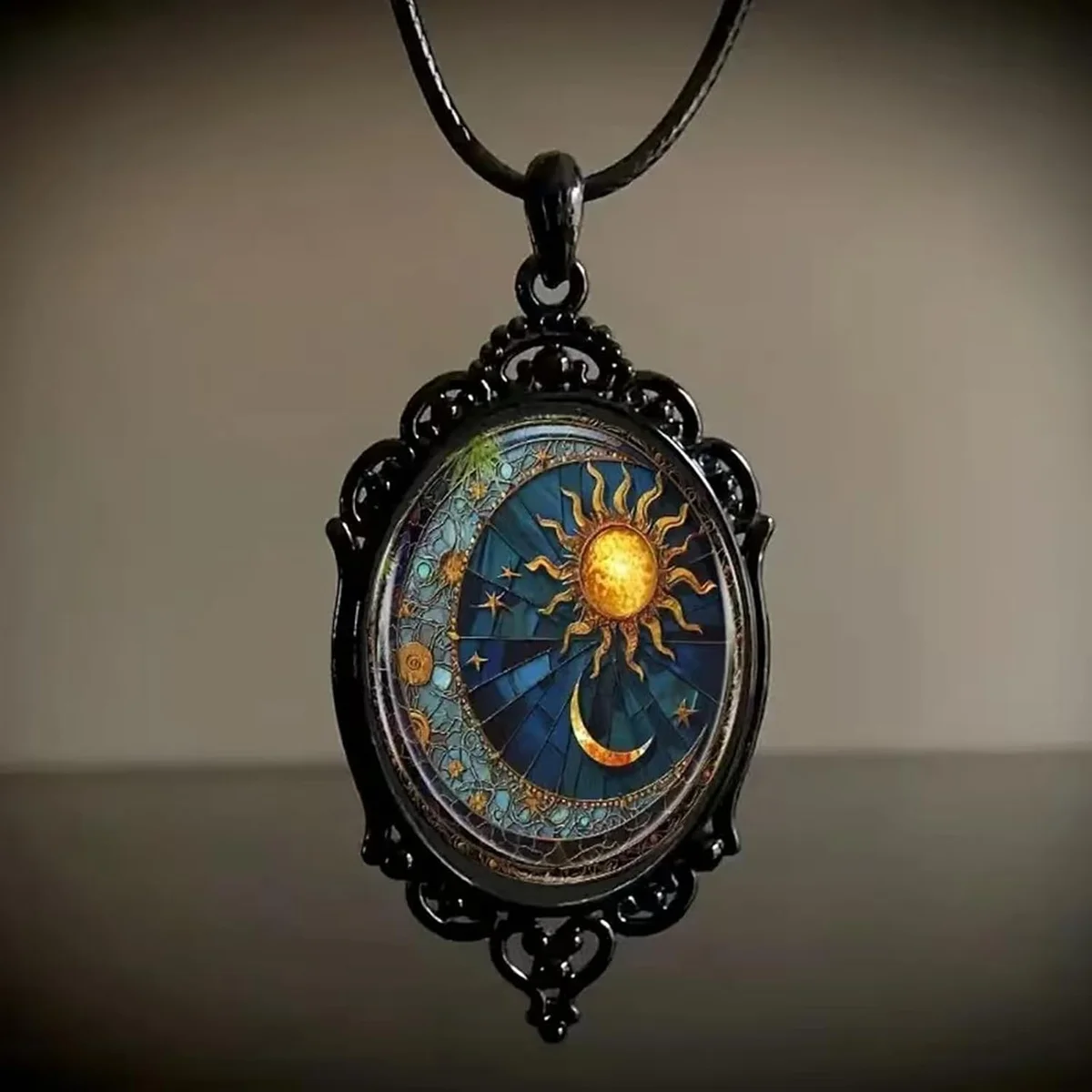 Gothic pendant necklace featuring a round glass cabochon printed with a vintage crescent-moon face cameo, framed in dark antique metal with sun and moon motifs, strung on a braided rope chain and displayed with an elegant gift box