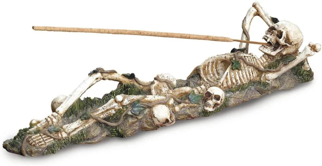 Skeleton-shaped incense burner holder designed to hold incense sticks and collect ash